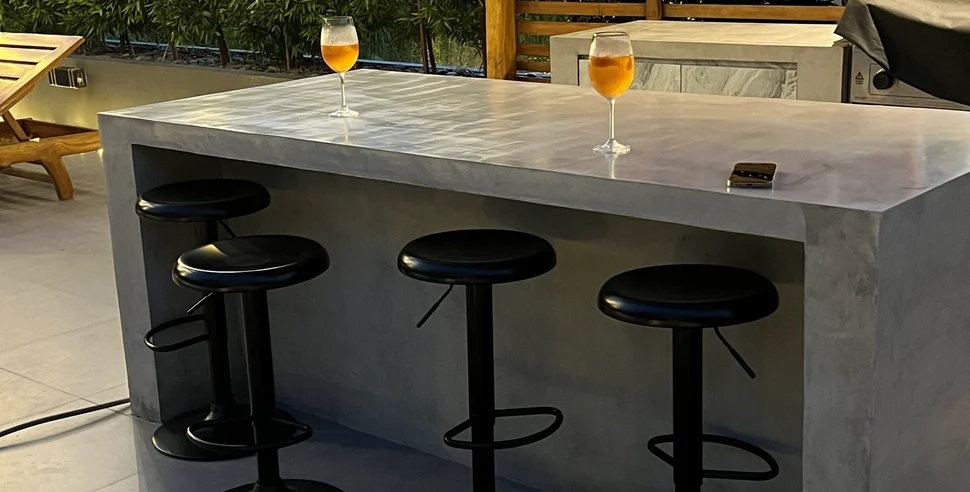 An outdoor space with microcement surfaces in tropical daylight.