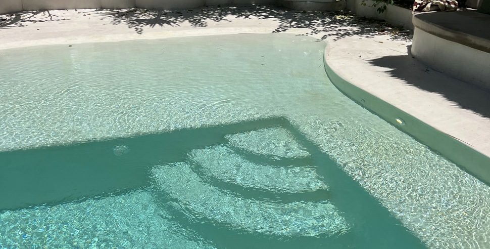 A pool surround and water feature finished in microcement.
