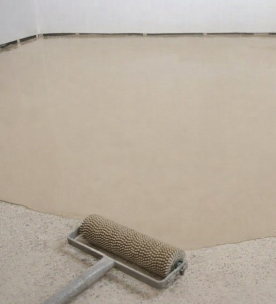 Floor Leveling compound being poured onto a floor and flowing out level.